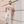 Man wearing a white t-shirt with text LEGEND CITY and graphics, with coordinates,standing against a textured wall.