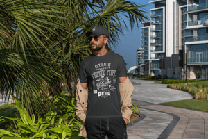 Man wearing a black t-shirt with text "Authentic-Misty Mountain Hops Beer," standing outdoors near modern buildings and palm trees.