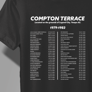 A close-up of a black T-shirt with a white printed list of Compton Terrace Concert list with dates, shown on a model against a dark background.