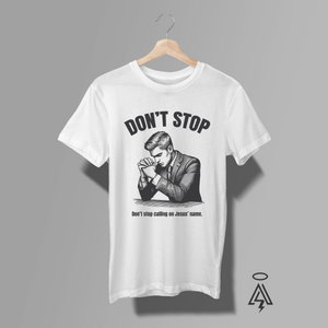 A white short-sleeve graphic t-shirt. The shirt features a black-and-white graphic of a man in a suit praying, with the text 'DON'T STOP' above and 'Don't stop calling on Jesus' name.