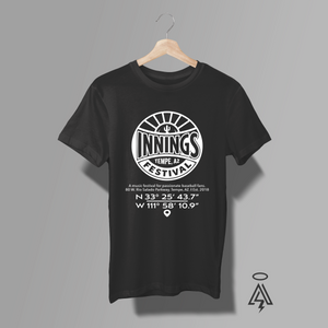 A black short-sleeve t-shirt. The shirt features a white circular graphic print on the chest with the text 'INNINGS TEMPE, AZ FESTIVAL' and coordinates below it.