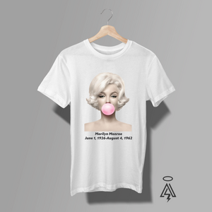 This striking white tee pays tribute to one of the most iconic women in entertainment history — Marilyn Monroe — blending classic Hollywood beauty with modern, playful attitude. Front and center is a clean, high-contrast portrait of Marilyn in her signature platinum waves and flawless vintage styling, captured with a soft, airbrushed finish that feels both elegant and contemporary.